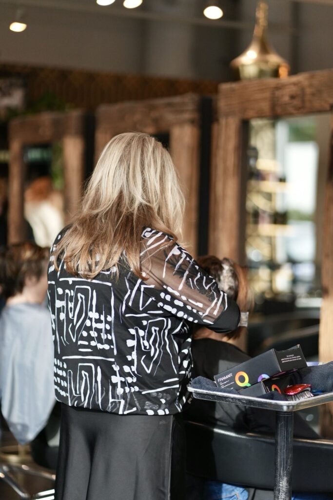 Stylist sectioning a blonde client's hair during a cut
