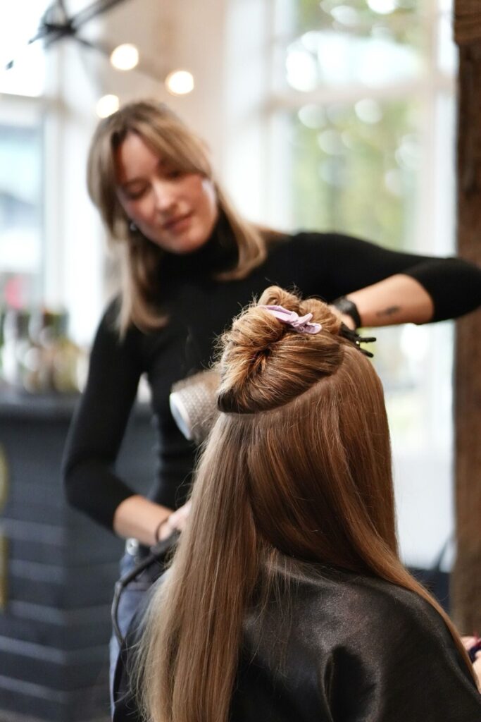 Stylist securing a client's hair while styling