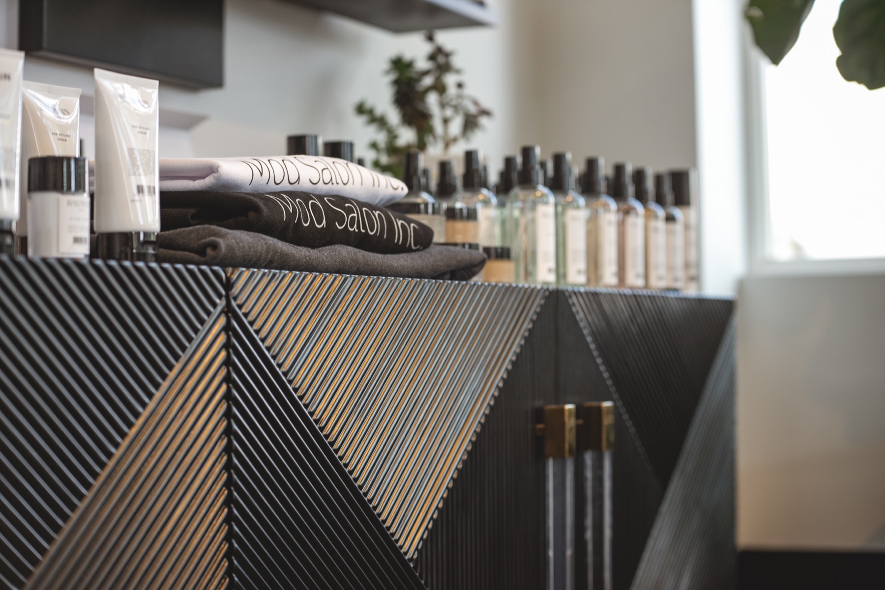Best Kelowna Hair Salon: Reception counter with a geometric gold front and MOD Salon towels