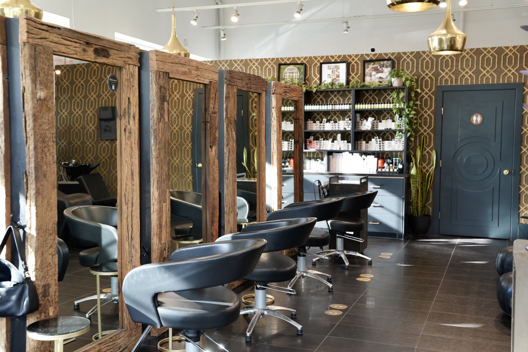 Best Kelowna Hair Salon: Styling stations with wood-framed mirrors and black salon chairs