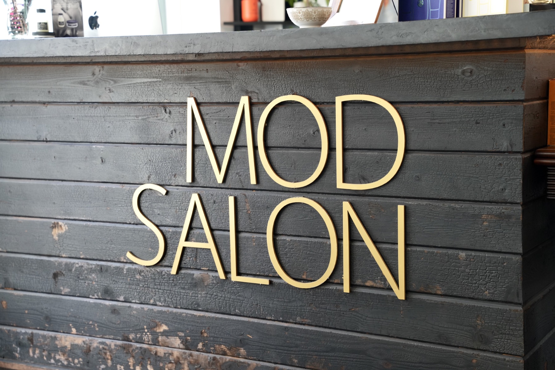 Best Kelowna Hair Salon: Gold MOD Salon lettering on the reception desk