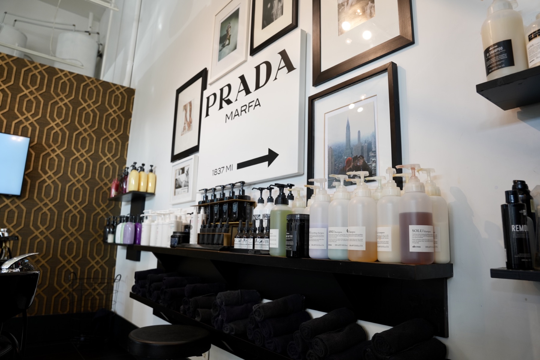 Best Kelowna Hair Salon: Hair care products and folded towels below framed prints