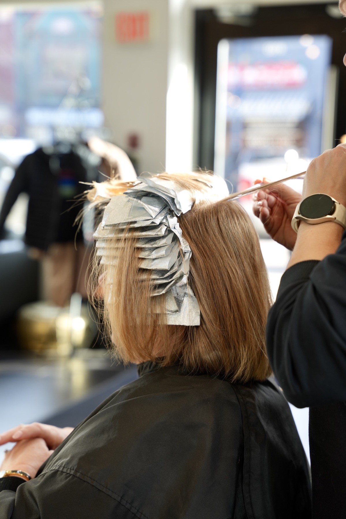 Best Kelowna Hair Salon: Close-up of foil highlights being painted onto a client’s hair